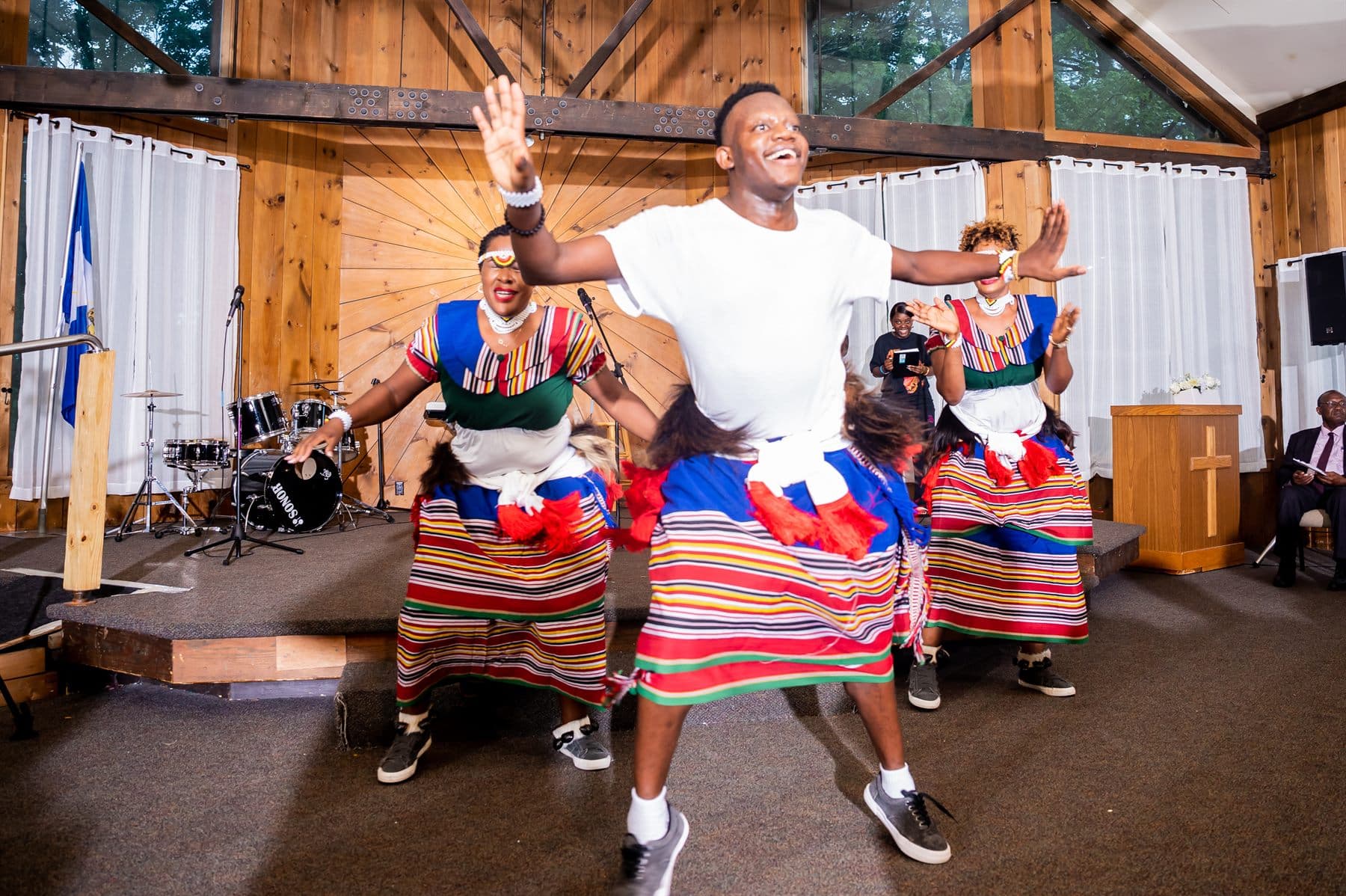 The dance troupe in traditional Kiganda dress mid-leap during a performance