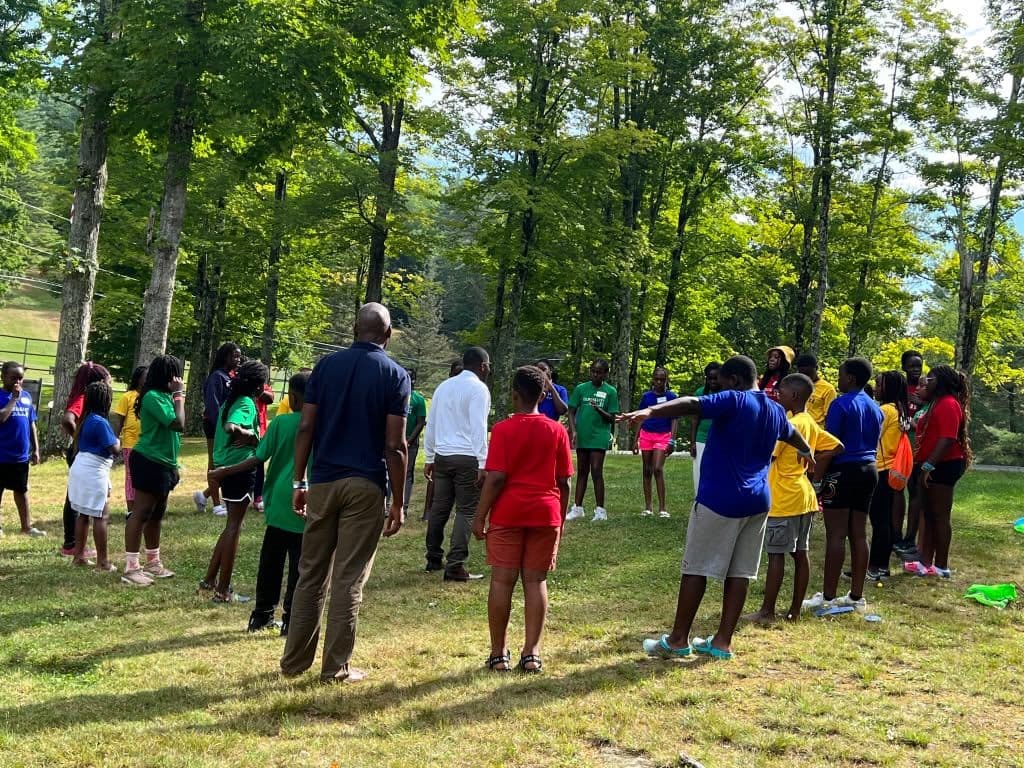 Campers and leaders playing field games together on the grass
