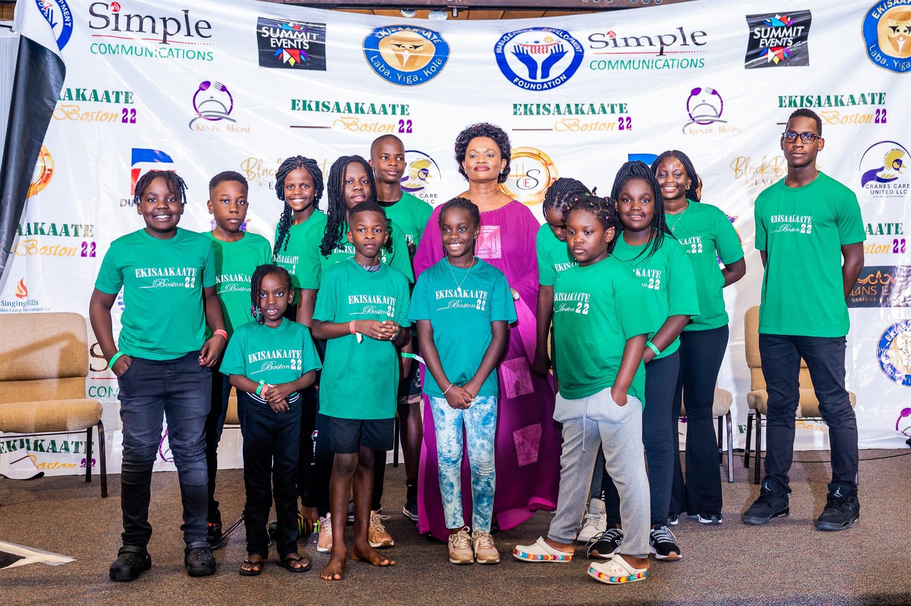 The green team photographed with Her Royal Highness in front of the sponsors wall