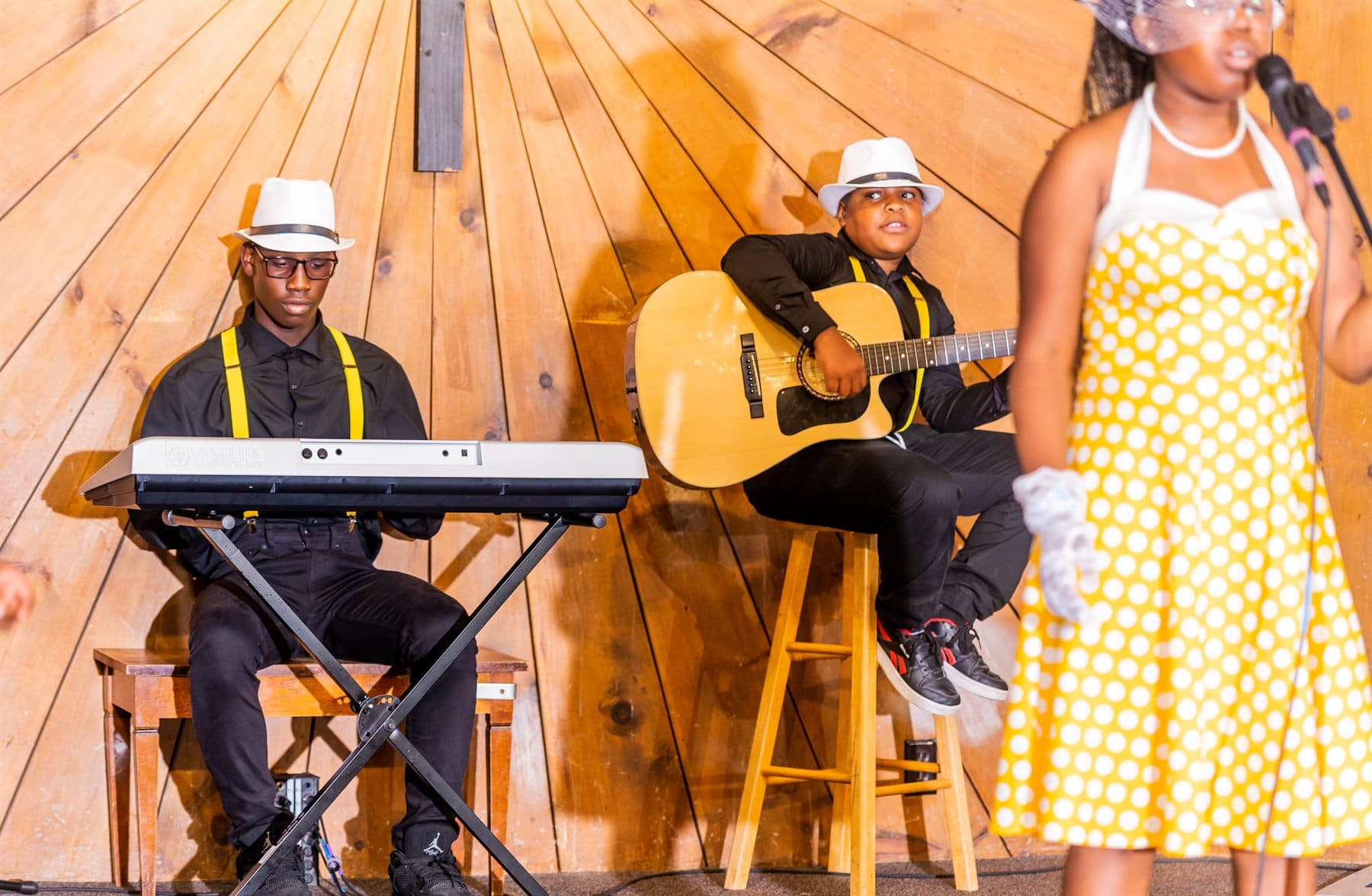 Young musicians on keyboard and guitar accompanying the singers