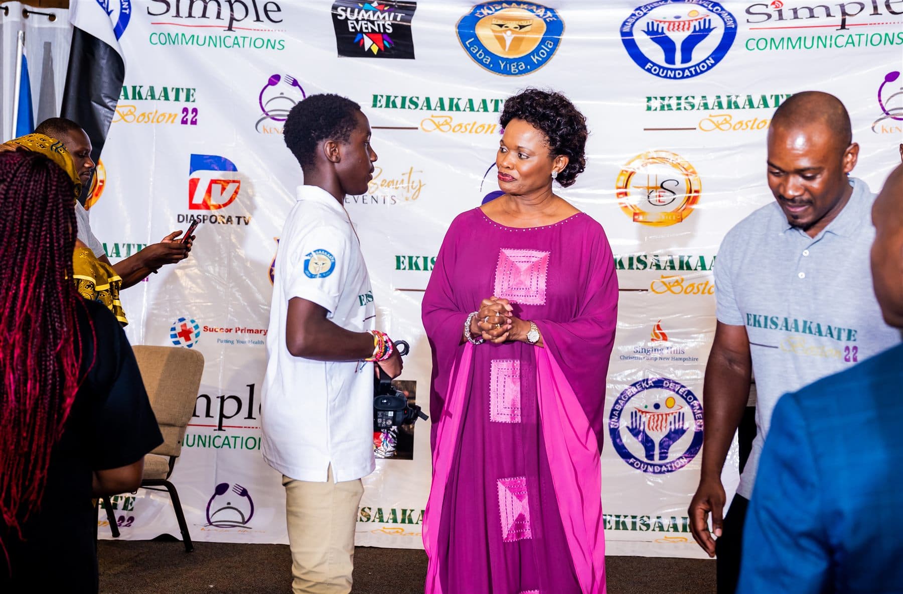 Her Royal Highness the Nnaabagereka greeting a young camper personally in front of the Ekisaakaate Boston sponsors wall