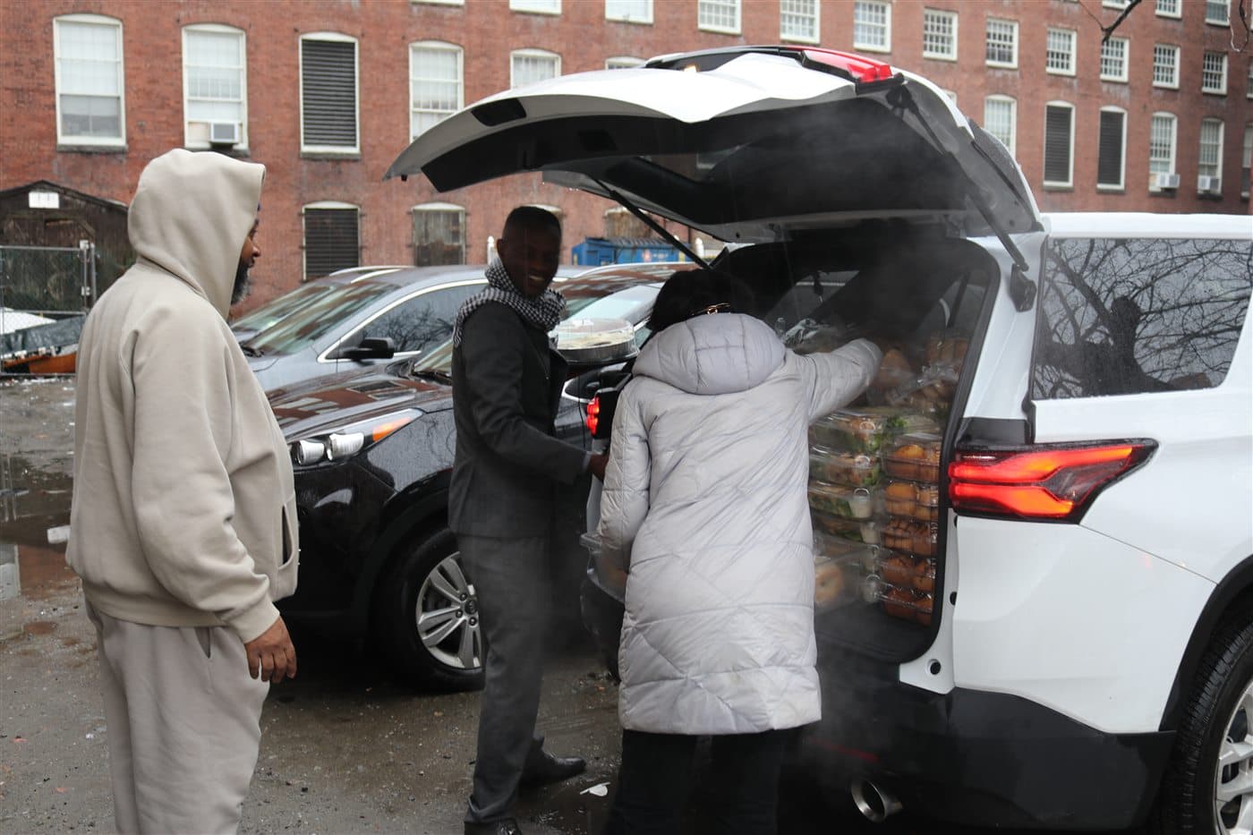 Outreach volunteers gathered at the open back of a loaded vehicle