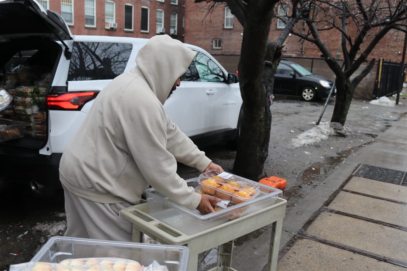 An outreach volunteer placing prepared food onto a cart outside