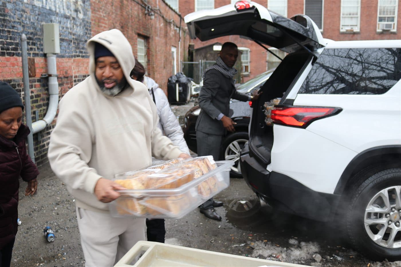 A volunteer carrying trays of prepared food on a Boston street
