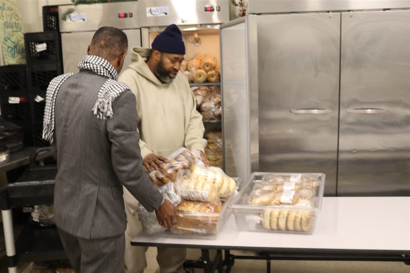 Two outreach volunteers sorting packaged bread at a table