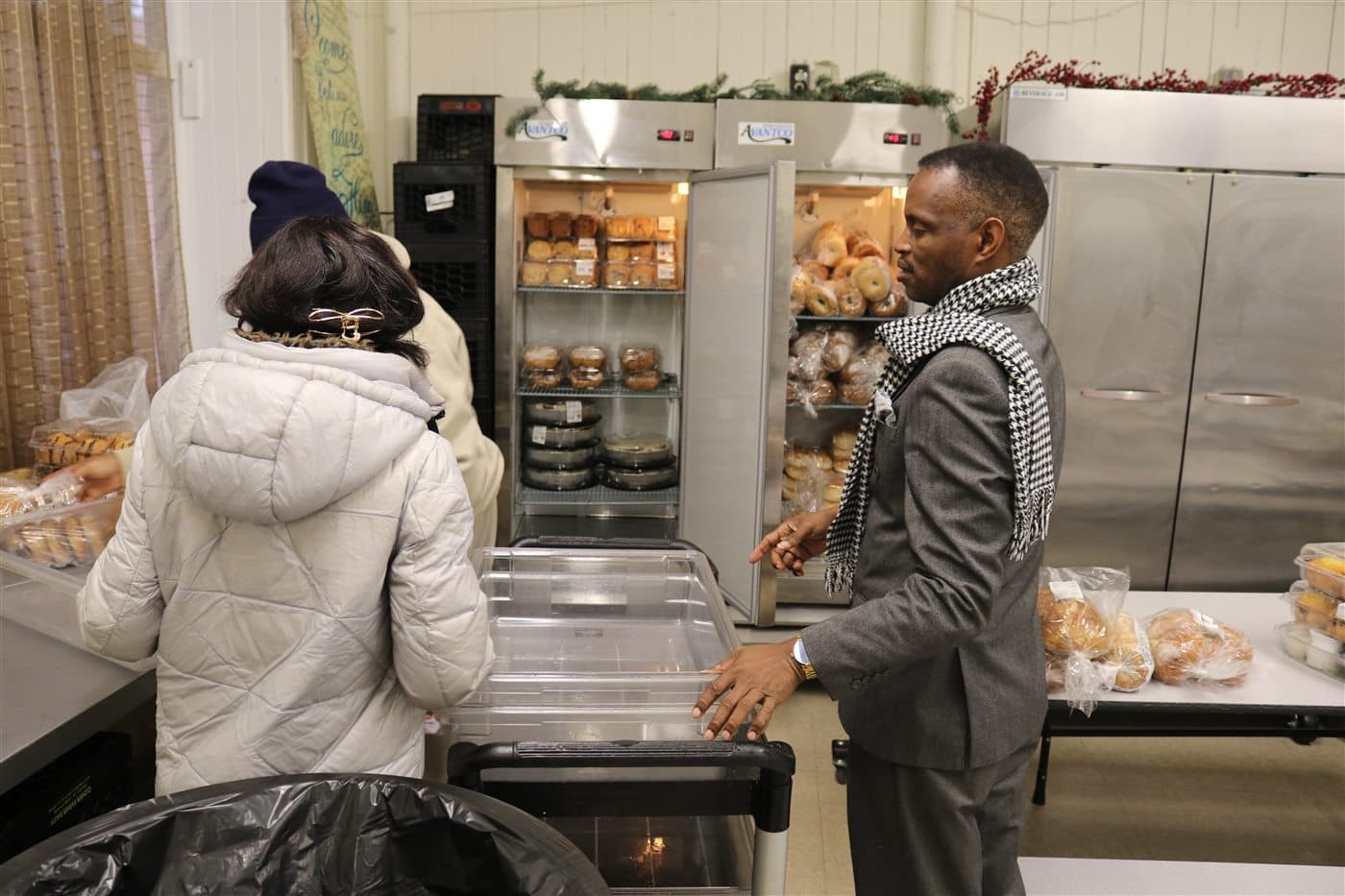 Outreach volunteers working beside stocked food storage