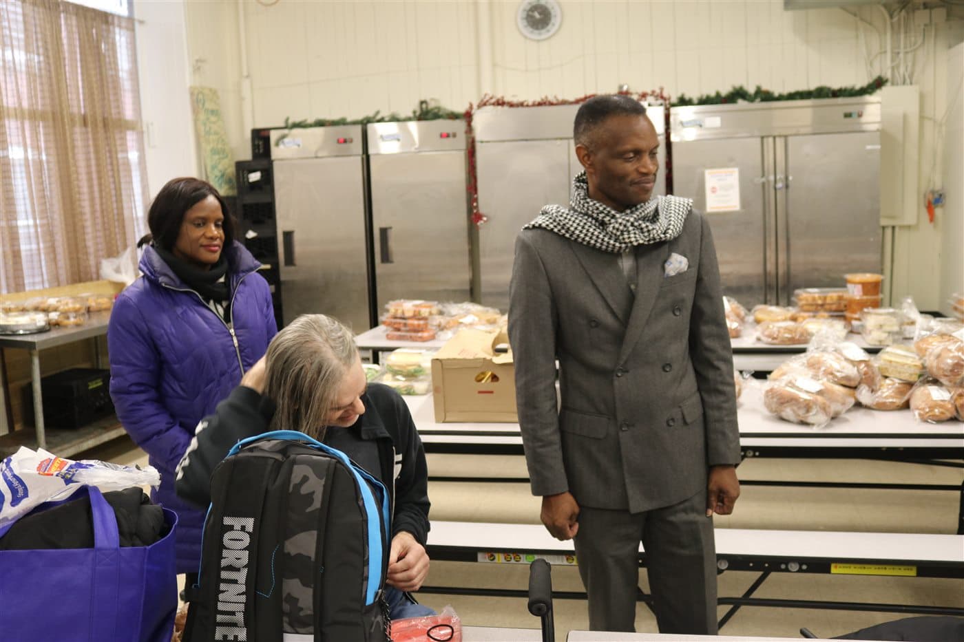 Pastor Ssuuna speaking with community members around a table