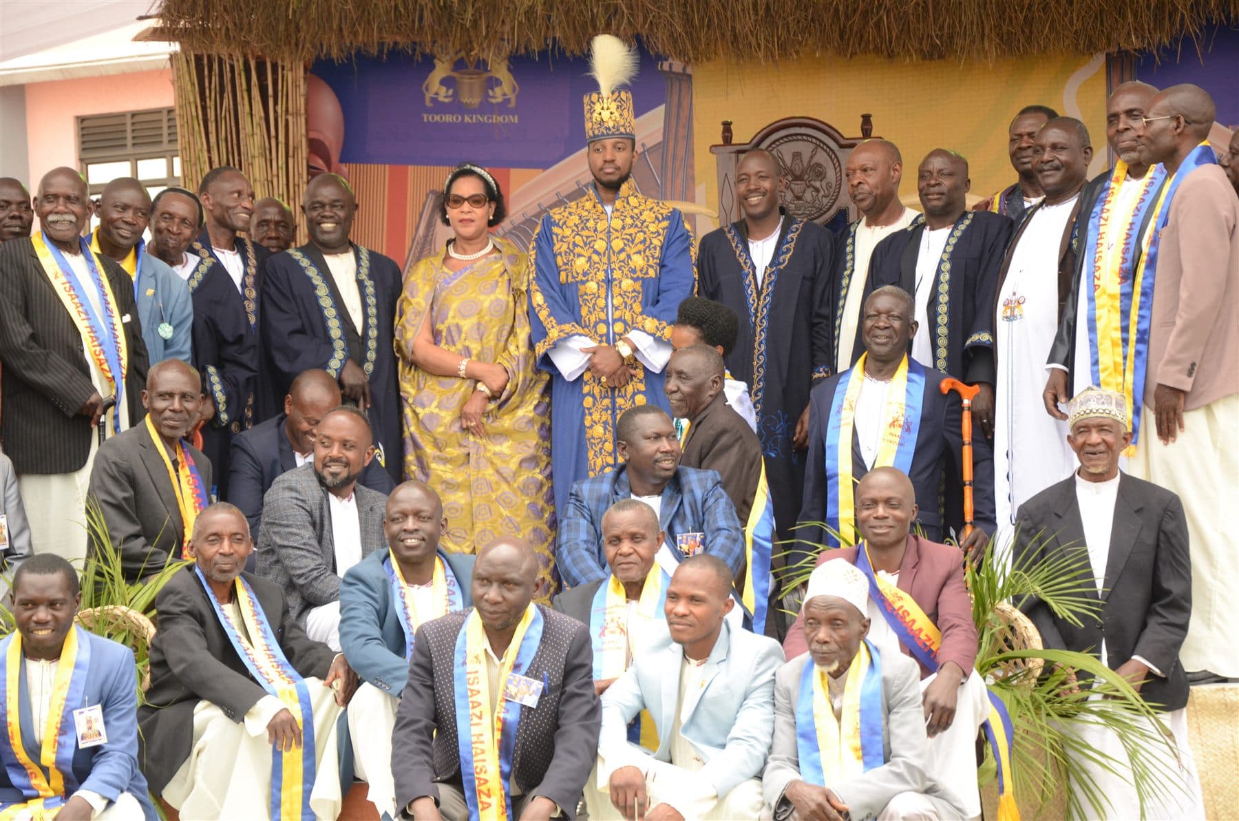 King Oyo in royal robes standing with Queen Mother Best Kemigisa, kingdom chiefs and ministers during the 29th Empango celebration